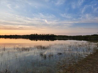 Sunrise cloudscape reflected in calm water of Nine Mile Pond in Everglades National Park, Florida in April.
