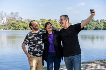 Group of friends of different ages taking a selfie in a lake. Happy expressions. Copy space