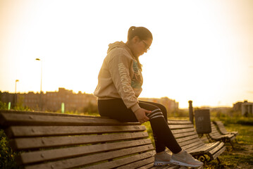Young latina female sitting at sunset park