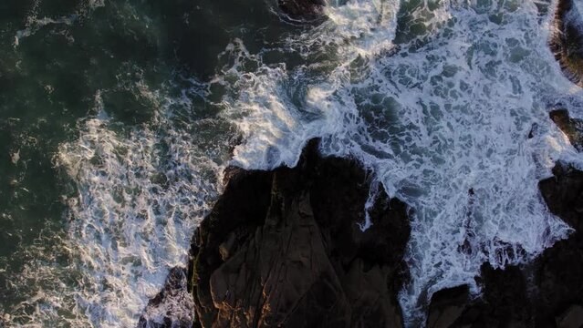 Waves crashing on the rocks of coast at dawn