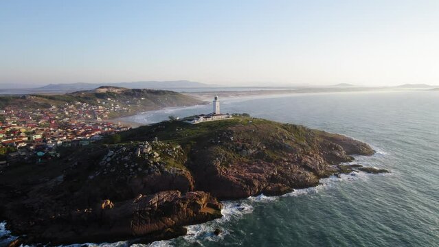 Drone footage of a lighthouse at sunrise, Farol de Santa Marta, Laguna, Santa Catarina, Brazil