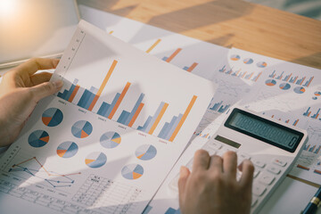 Businessman or accountant holding pen and analytical chart papers calculate company budget and...