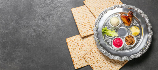 Passover Seder plate with traditional food and matza on grey background with space for text