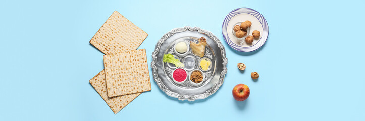 Passover Seder plate with traditional food on light blue background, top view