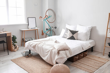 Interior of light room with big bed and modern bicycle
