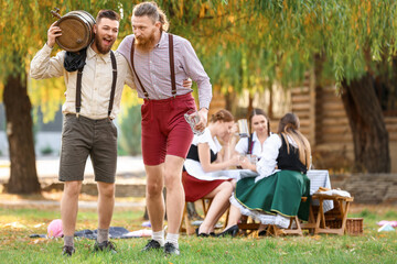 Fototapeta premium Drunk men with beer celebrating Octoberfest outdoors