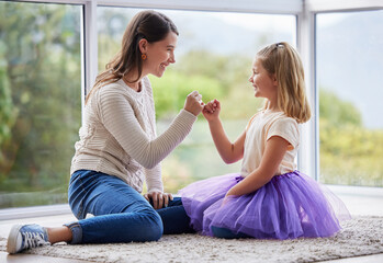 This promise will never be broken. Shot of a young mother and daughter making a pinky promise at...