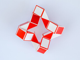 red and white bicolor magic snake Transformable twist puzzle in shape of ninja star isolated on...