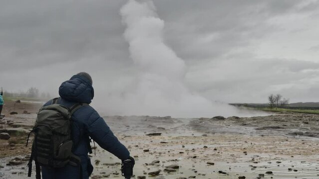 Hiker Watching Spray And Steam Of Erupted Geyser