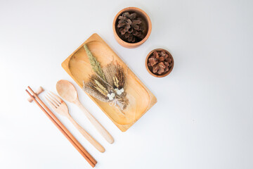 wooden plate with wooden utensils on a white table