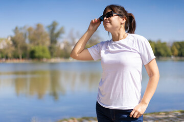 Portrait of a young Latin woman looking to the side, at a lake with copy space