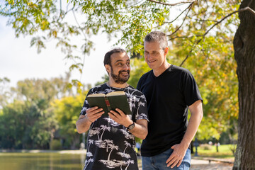 Couple of mature men reading in a lake, with a happy and relaxed attitude