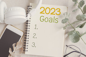 2023 New year resolution and Goal list on notepad  with phone and headphone