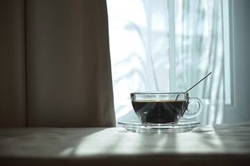 coffee cup on the bed in the morning wake up time with sunshine through white curtain