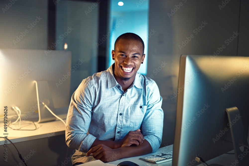 Poster success may at times require the extra hours. portrait of a young businessman working late on a comp