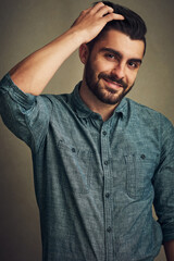 Fototapeta premium Theres always time for a fresh new cut. Studio shot of a handsome young man posing with his hand in hair.