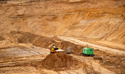 Textural sand, with  relief surface, multi-colored layers and different in size of granules, in outdoor sand career, after mining ore and sand for construction.