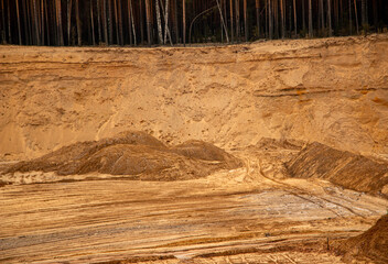 Textural sand, with  relief surface, multi-colored layers and different in size of granules, in outdoor sand career, after mining ore and sand for construction.