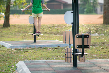 Fitness equipment, outdoor with unrecognized woman exercising at the background. Sports or healthy lifestyle concept.