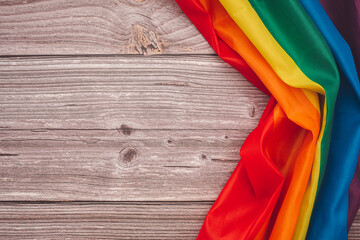 Top view of the rainbow flag or LGBT over a wooden table