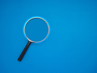 Search concept. A magnifying glass on a blue background with copy space for text