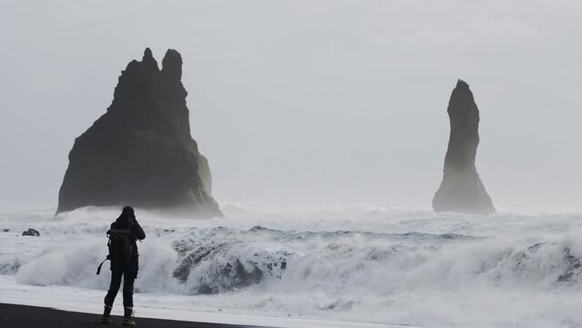 Photographer Running To Evade Tide With Camera On Black Sand Beach