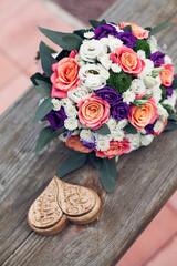 Beautiful wedding bouquet of white orange and pink roses with a decorative brown box for rings on a wooden background