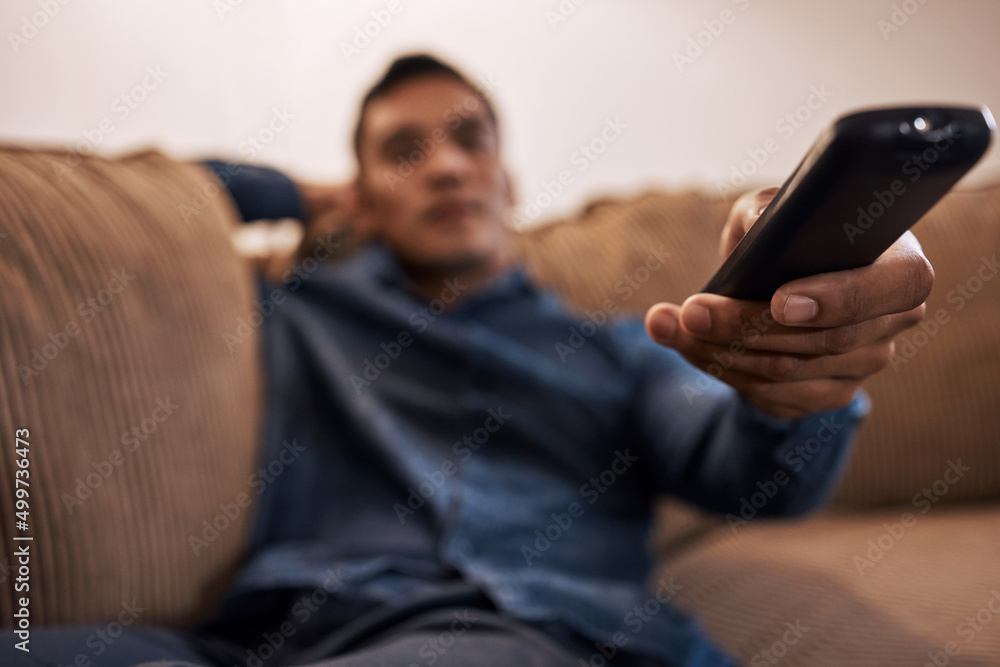 Canvas Prints Oh look theyre playing my favourite film. Shot of a young man holding the remote while watching TV.