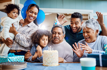 Make a wish. Shot of a little boy celebrating his birthday with his family at home.