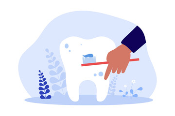Human hand holding toothbrush with toothpaste to clean tooth. Tiny persons healthy dental care flat vector illustration. Oral hygiene, health concept for banner, website design or landing web page
