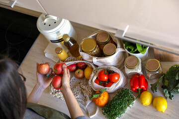Young Asian woman takes out a ripe apple from a cotton bag. Vegetarian woman.