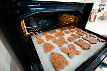 Baking sheet with raw cookies in front of the oven
