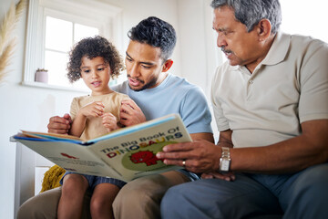 Family time comes in various forms. Shot of a little girl reading a book with her father and grandfather at home. - Powered by Adobe