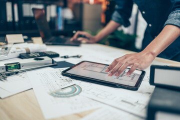 Architect engineer use tablet to read drawing design. House planning design and construction concept.