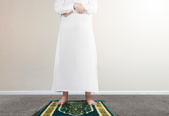Close up view of a Muslim man in a praying position (salat) on a prayer rug
