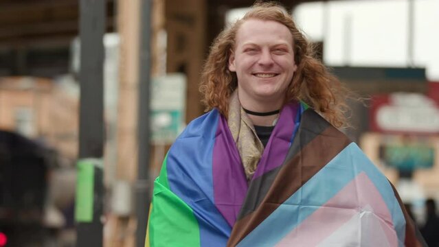 Happy LGBTQ person posing with a flag