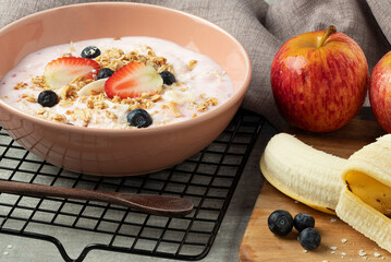 Strawberry yogurt with granola and fruits.