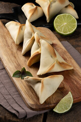 Arabic sfiha with lemon on cutting board.
