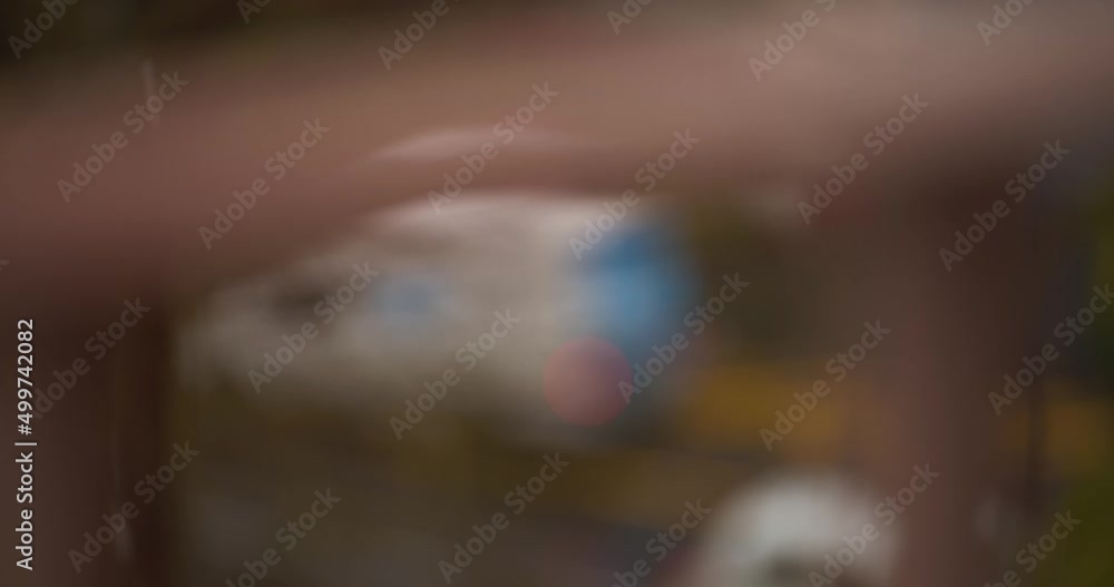 Poster blurred view of raindrops falling outside with street view, static view from inside