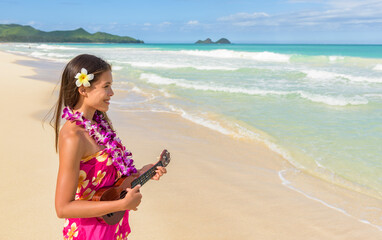 Hawaii luau ukulele hula dancing woman playing ukulele guitar on beach vacation travel wearing...