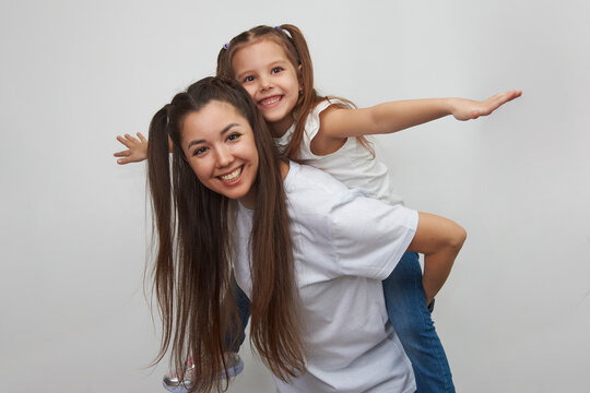 Happy woman and child girl 5-6 years old having fun