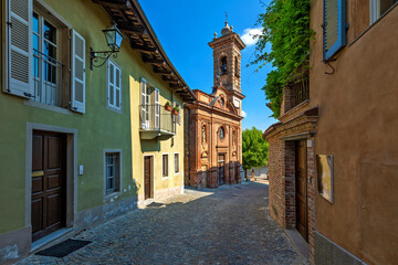 Obraz premium Narrow cobblestone street and small church in Guarene, Italy.
