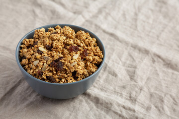 Homemade Granola with raisins and almonds  in a Bowl, side view. Space for text.