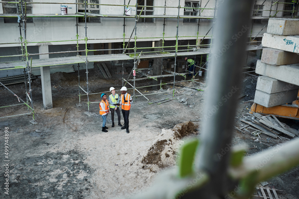 Poster the construction business is booming. shot of a group of building contractors having a discussion wh