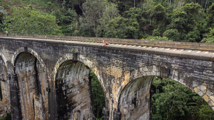 Beautiful girl running across Nine Arches Bridge, Ella, Sri Lanka.