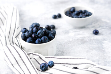 Organic fresh farm big macro blueberry in a white ceramic bowl breakfast mood. Food photography in a high key, light colors. Natural vegetarian dessert.