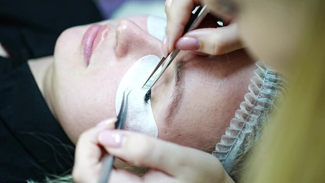 Eyelash extension procedure in beauty salon. Lashes close up. Concept spa lash. 