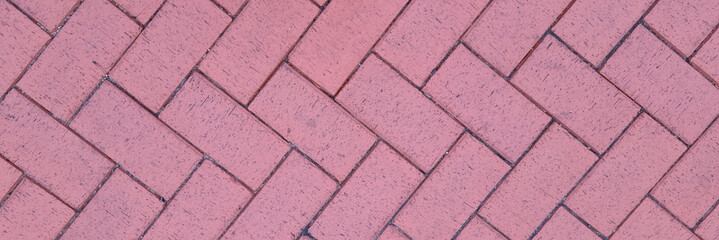 Paving slabs laid out in shape of herringbone on city street background