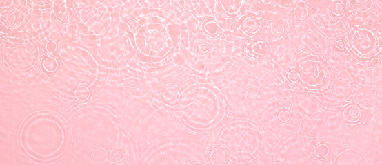 Abstract summer banner background Transparent pink clear water surface texture with ripples, splashes. Water waves in sunlight, copy space, top view. Cosmetics moisturizer micellar toner emulsion