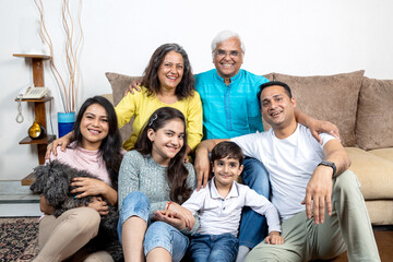 indian family sitting on sofa at home